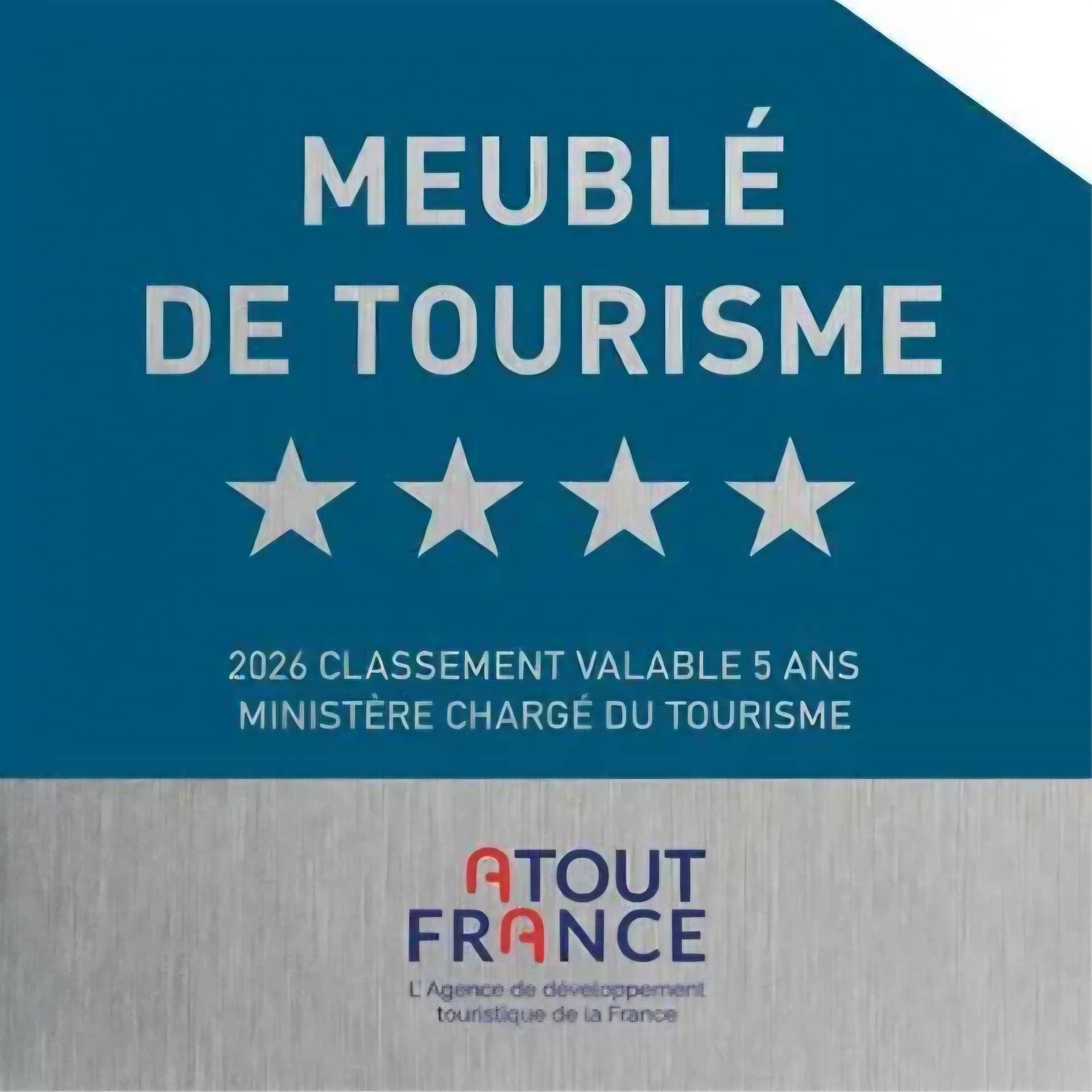 La plaque de classement affichée dans la maison : meublé de tourisme quatre étoiles, classement 2026 valable cinq ans, Ministère chargé du Tourisme, Atout France.